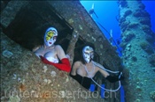 Zwei Unterwassermodels posieren mit venezianischen Masken im Steuerstand der Ghiannis D. (Ägypten, Rotes Meer), underwater models  at the shipwreck of Ghiannis D. (Aegypt, Red Sea)