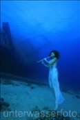 Unterwassermodel posiert mit Querföte vor dem Wrack der Ghiannis D. (Ägypten, Rotes Meer), underwater model and flute in front of the shipwreck Ghiannis D.(Aegypt, Red Sea)